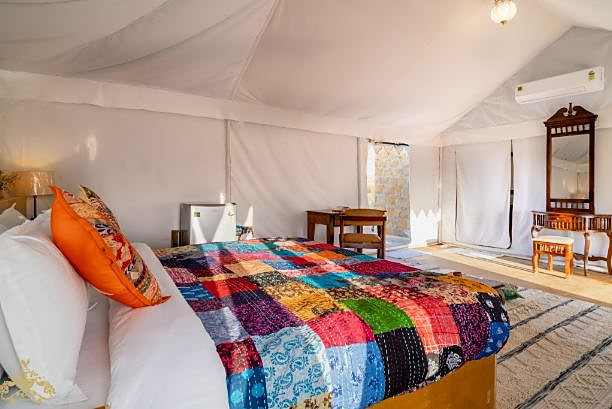Deluxe camp tent in Jaisalmer with colorful Rajasthani interior at Jadam Resort